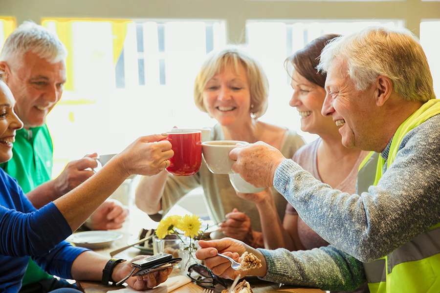 Gute gelaunte Männer und Frauen am Kaffeetisch beim Gruppentreffen der Selbsthilfegruppe KnochenKraft
